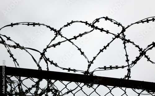 Barbed wire against the gray sky.