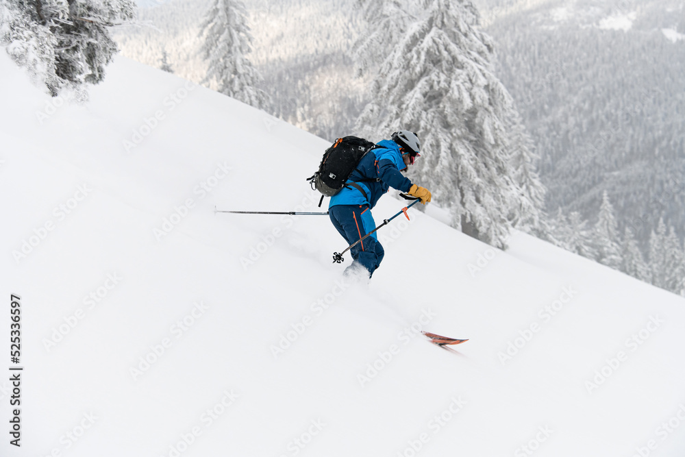 side view on skier riding down slope. Freeride skiing concept side view on skier riding down slope. Freeride skiing concept