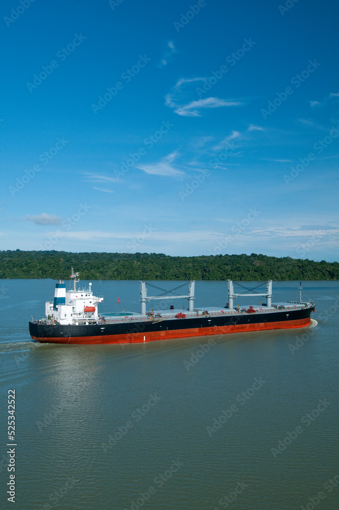 Aerial view of  grain cargo ship in transit crossing Gatun lake in the Panama Canal. - stock photo