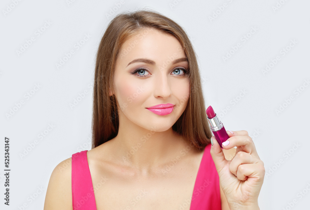 Beauty portrait of a young gir holding pink lipstick. Beauty portrait of a young gir holding pink lipstick.