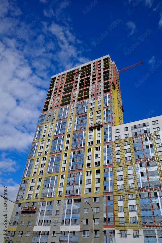 A multi-storey residential building under construction on a summer day