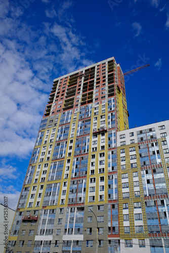A multi-storey residential building under construction on a summer day