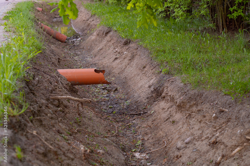 sewer pipes sticking out of the ground above a trench dug for sewage