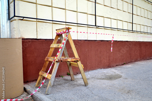 Temporary fencing of repair work on the facade of the building on a summer day