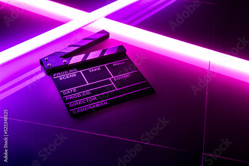 Foto Clapperboard movie slate on Glowing neon lighting background