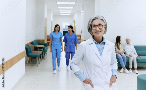 Bilde på lerret Friendly female general practitioner wearing medical uniform standing in modern