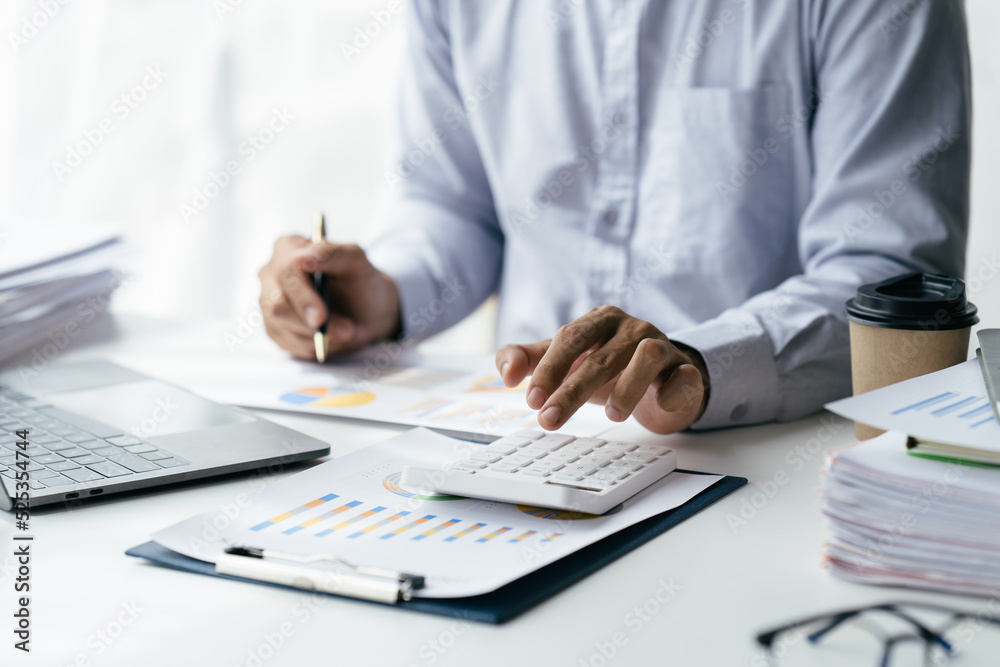 An Asian male finance worker or accountant is reviewing the investment results. To report at the meeting, audit ideas And investment results An Asian male finance worker or accountant is reviewing the investment results. To report at the meeting, audit ideas And investment results