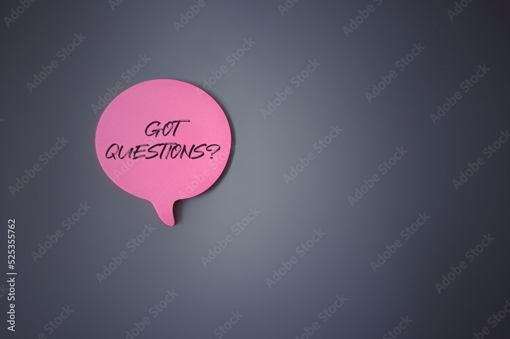 Top view image of speech bubble with text GOT QUESTIONS? on grey dark background. Copy space for text
