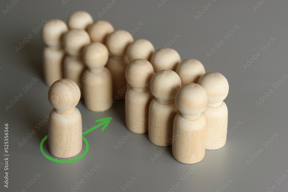 Selective focus image of one wooden doll join the group. New member, hiring, filling a vacancy concept. Selective focus image of one wooden doll join the group. New member, hiring, filling a vacancy concept.