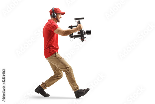 Full length profile shot of a camera operator using a stabilizer and recording with camera photo