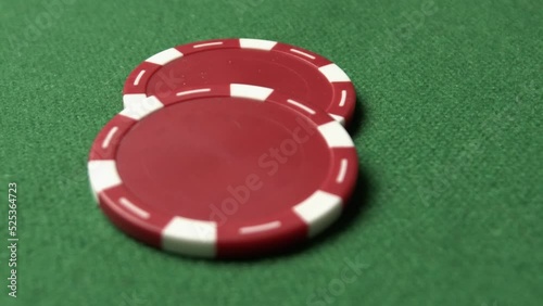 A close-up poker shot of color chips, man's hand doing a bet, red chips sliding toward camera 