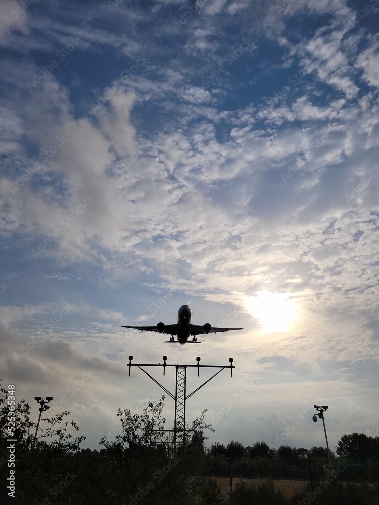 Airplane landing in the sunset. Clouds in the sky Airplane landing in the sunset. Clouds in the sky