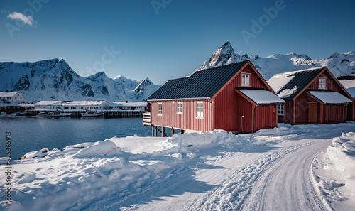 Wonderful Morning landscape on Lofoten islands in winter season. Impressive Winter scenery with snowcapped mountains, traditional red fisherman huts, rorbu. Hamnoy village of an ideal resting place.