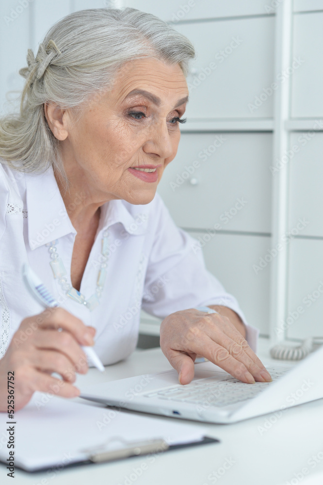 senior female doctor working at her cabinet senior female doctor working at her cabinet