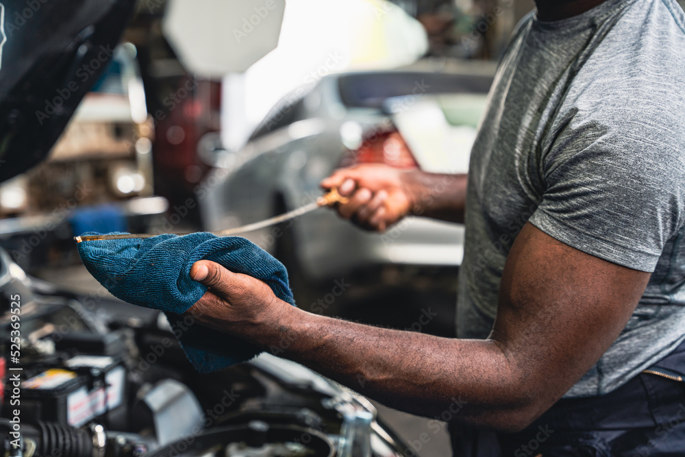 Mechanic pulling out the dipstick to check the engine oil level. foto ...