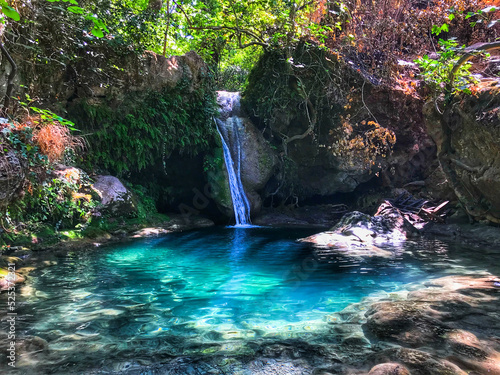 Turgut Falls a small scale waterfall white silky water falling into aquarium blue still pond Orhaniye Mahallesi Marmaris Mugla Turkey stock photo