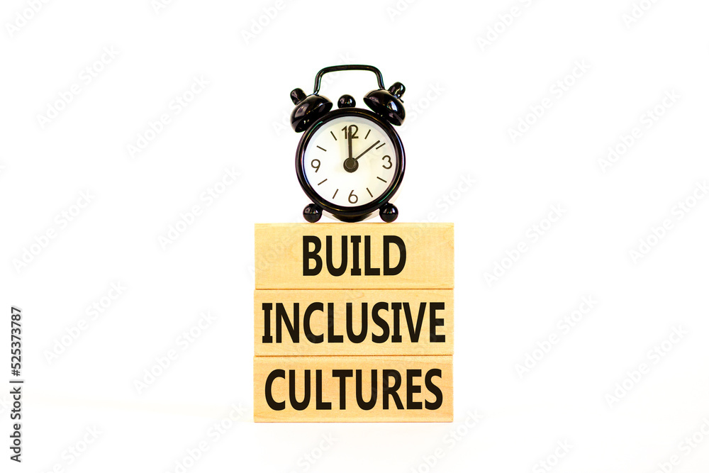 Build inclusive cultures symbol. Concept words Build inclusive cultures on blocks. Black alarm clock. Beautiful white table white background. Business build inclusive cultures concept. Copy space. Build inclusive cultures symbol. Concept words Build inclusive cultures on blocks. Black alarm clock. Beautiful white table white background. Business build inclusive cultures concept. Copy space.