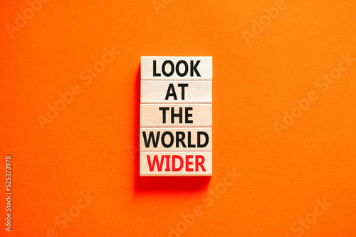 Look at the world wider symbol. Concept words Look at the world wider on wooden blocks on a beautiful orange table orange background. Business and look at the world wider concept. Copy space.
