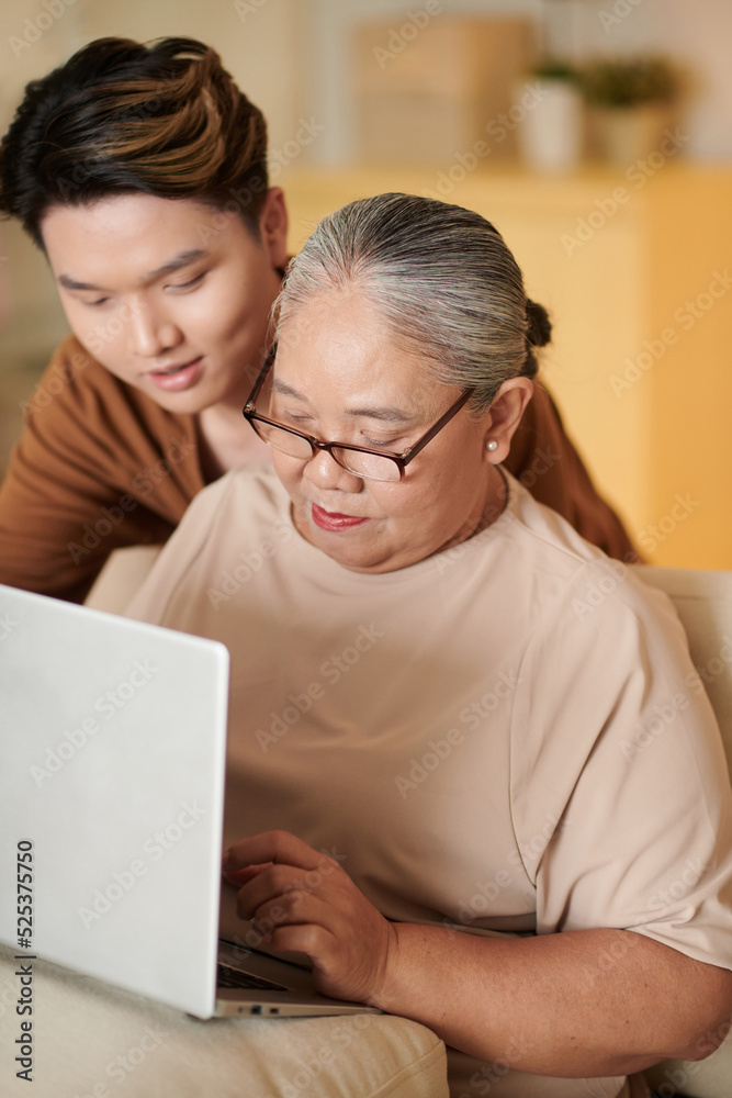 Man Teaching Grandmother to Work on Computer Man Teaching Grandmother to Work on Computer