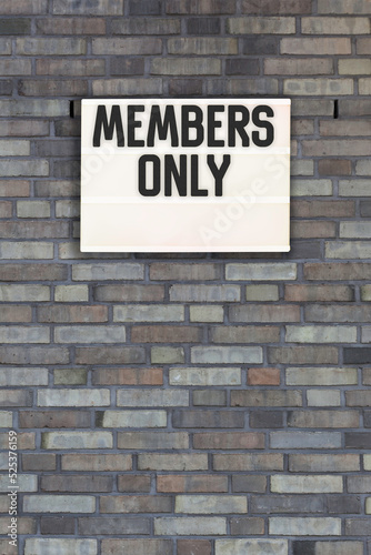 members only message in light box on brick wall