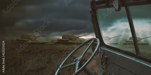 Interior of a vintage green convertible military 4x4 SUV car dashboard with a war scene of tank troops visible off focus through the windshield with copy space