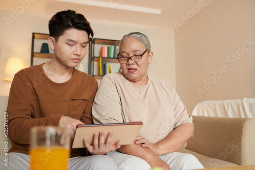 Man Installing Applications on Tablet of Grandmother