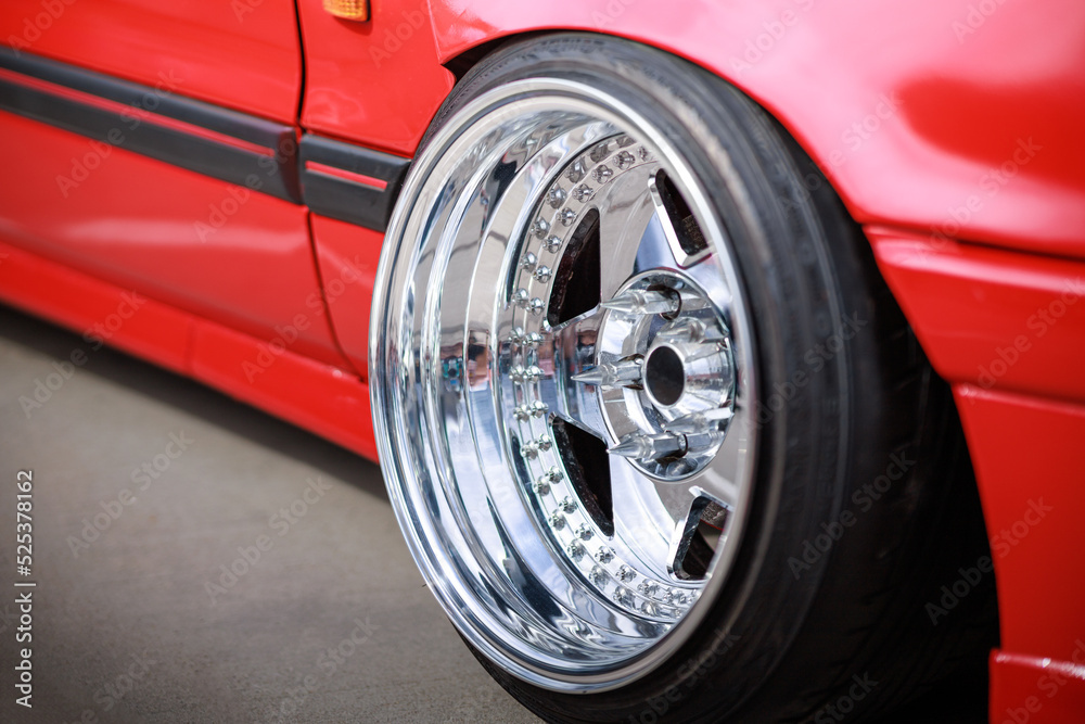 Tuned red sport car wheel, close up. Low rider sport auto.
