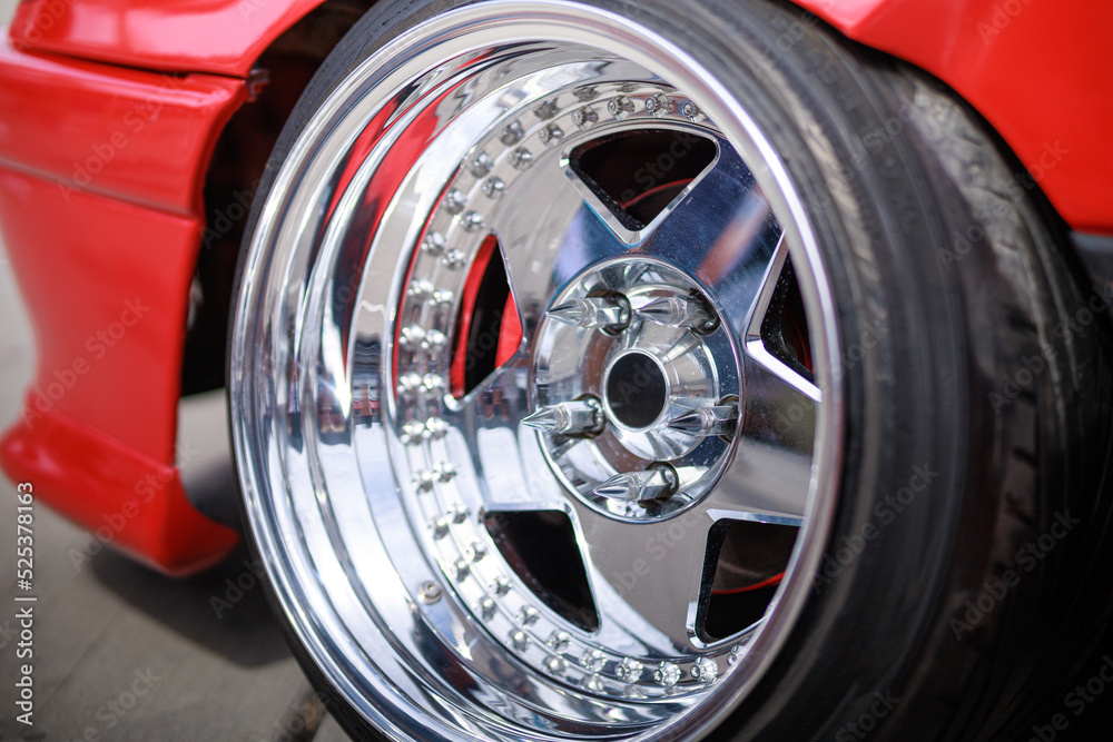 Fototapeta premium Tuned red sport car wheel, close up. Low rider sport auto. 