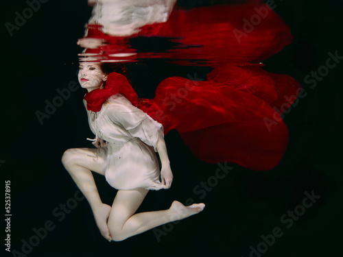 Woman in red hat and red scarf underwater
