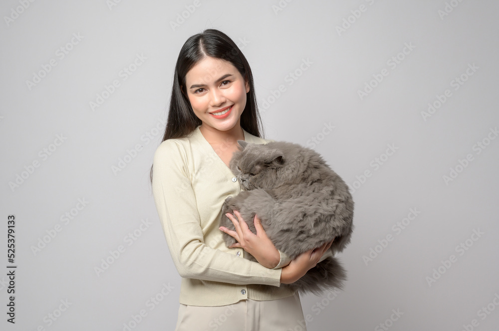 A young woman is holding lovely cat , playing with cat in studio on white background A young woman is holding lovely cat , playing with cat in studio on white background