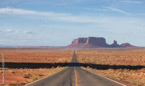 Scenic Road in the Dry Desert with Red Rocky Mountains in Background. Oljato-Monument Valley, Utah, United States.