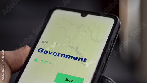 An investor's analyzing the government etf fund on screen. A phone shows the gov ETF's to invest