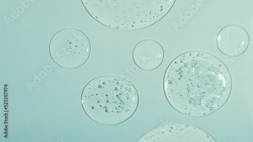 Top view of liquid cosmetics gel with bubbly structure on pastel cyan background,large banner.