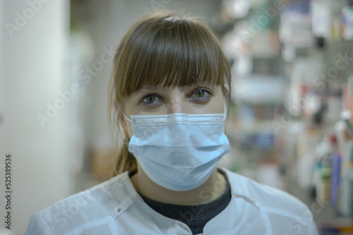 A tired pharmacist in a medical mask.