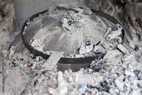 Cast iron Baking lid, Peka , covered with ashes. Traditional Croatian cooking dish