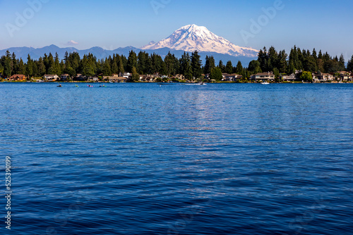 Fototapeta Naklejka Na Ścianę i Meble -  kayakers on blue colored water of Lake Tapps with snow capped Mt. Rainier on the background.