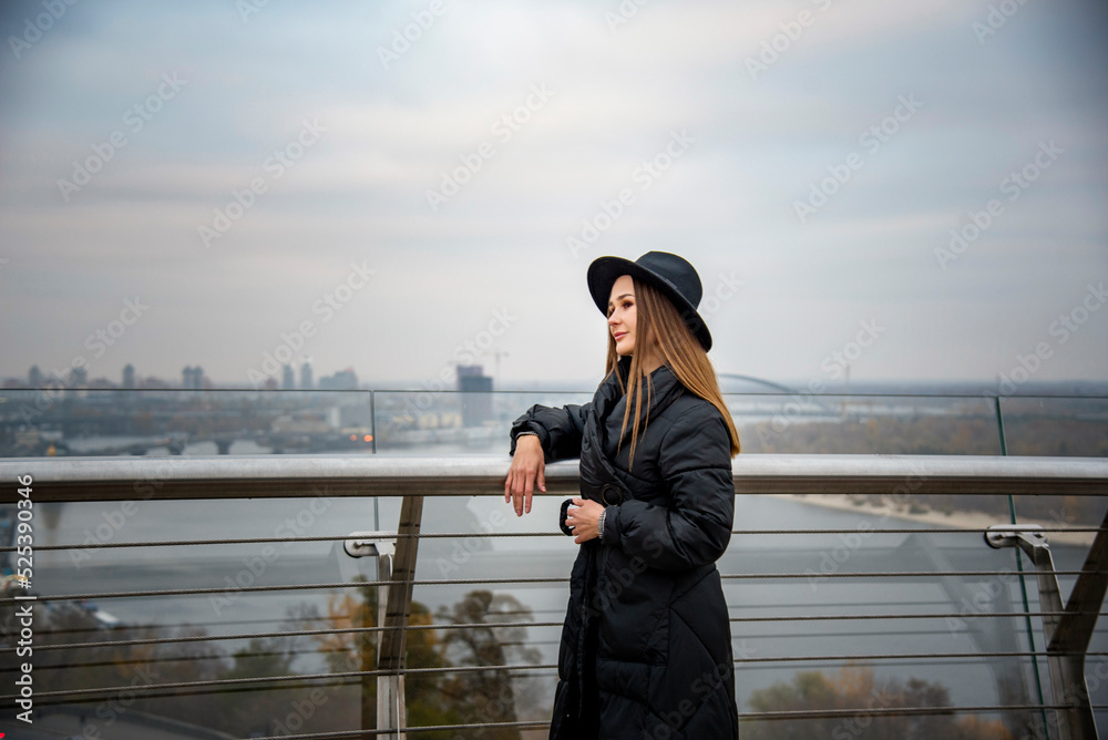 romantic beautiful brunette smiling girl in a black hat enjoying the autumn landscape romantic beautiful brunette smiling girl in a black hat enjoying the autumn landscape