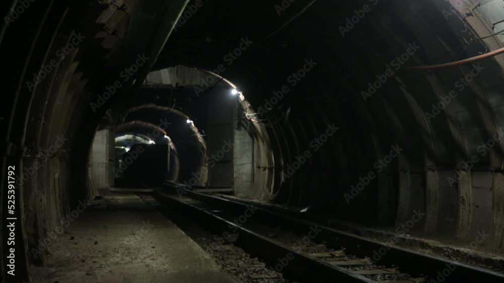 Movement of the train wagons in the mine tunnel. Technological equipment for mining underground, in the tunnel is poor lighting. Movement of the train wagons in the mine tunnel. Technological equipment for mining underground, in the tunnel is poor lighting.