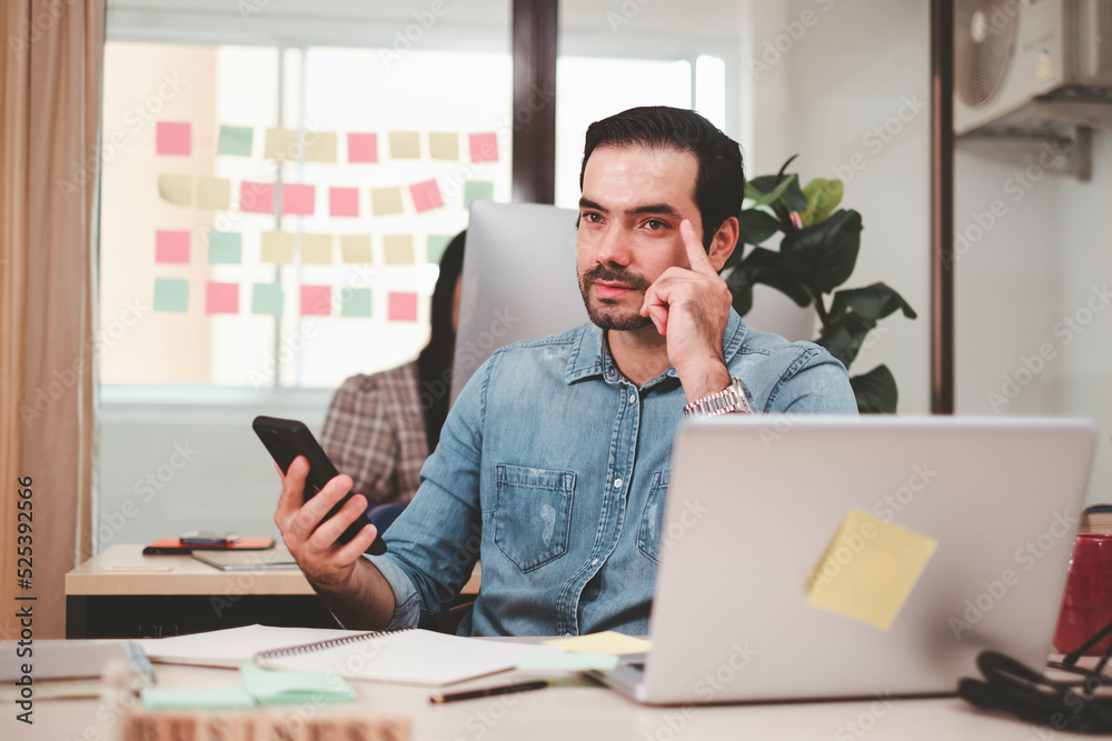 Portrait of smiling businessman with laptop sitting at desk in office. Cheerful casual caucasian employee, Handsome businessman using mobile phone. successful business working at office. mobile phone. Portrait of smiling businessman with laptop sitting at desk in office. Cheerful casual caucasian employee, Handsome businessman using mobile phone. successful business working at office. mobile phone.