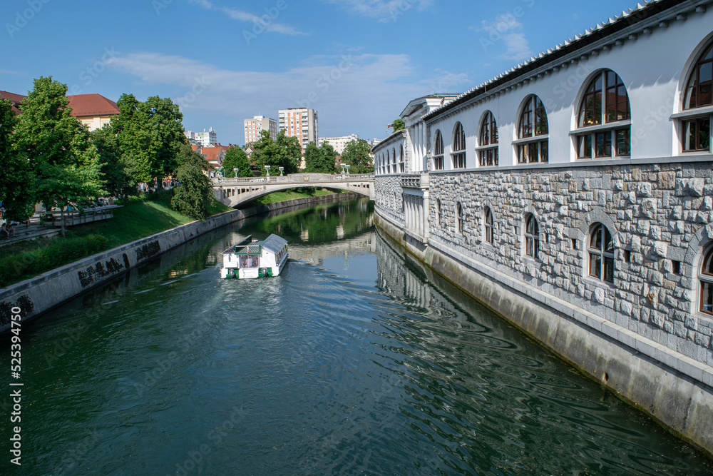 Naklejka premium The Ljubljanica River flows past Plečnik's Market toward the residential area of Ljubljana