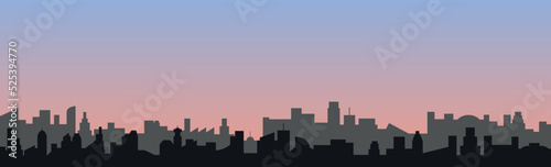 Vector drawing of a fictional city skyline and in the background a blue and pink sky of a late afternoon.