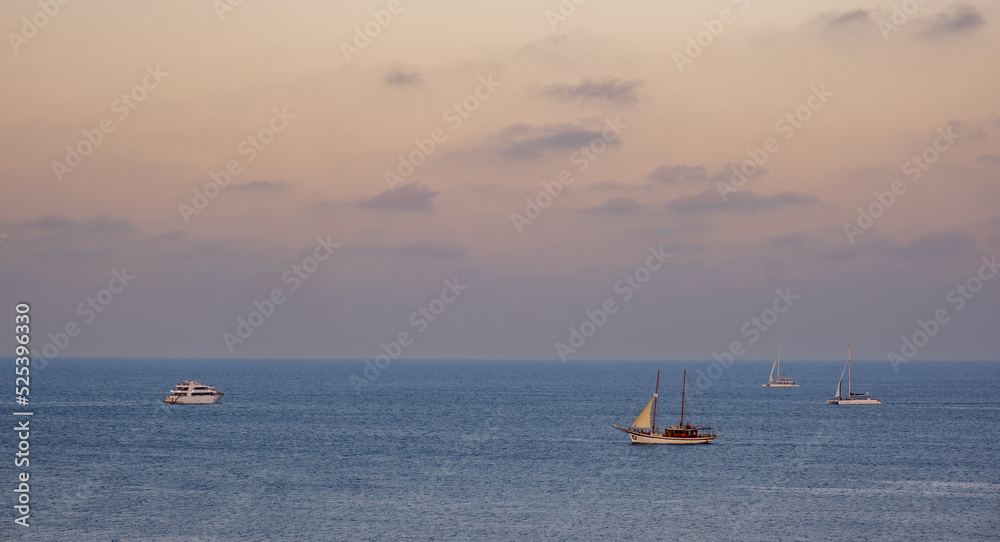 Sail boats and yachts sailing in the ocean at sunrise. Ayia Napa Cyprus