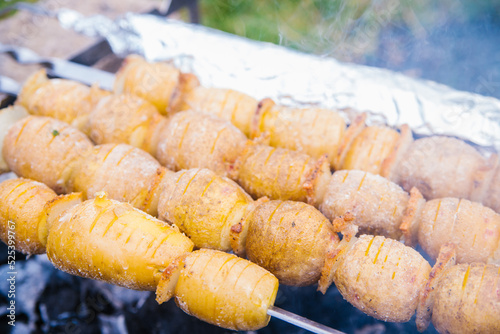 Whole potatoes in a rustic way on skewers. A delicious snack for a summer party with an outdoor barbecue or a picnic.Homemade food. Vegetarianism.