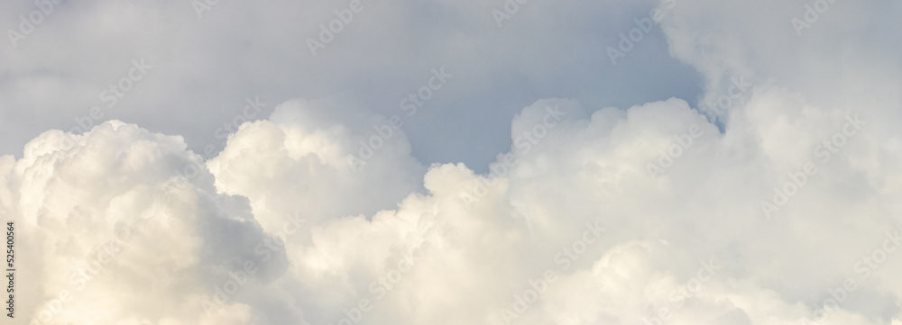 Obraz premium Big curly clouds in the light blue sky in soft pastel colors