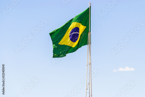 A bandeira do Brasil. Bandeira do Brasil voando, tremulando ao vento e com o céu azul ao fundo. photo