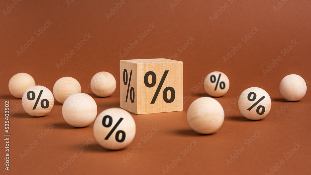 percent sign on wooden cubes against broun background with wooden balls. concept of sale and discount percent sign on wooden cubes against broun background with wooden balls. concept of sale and discount