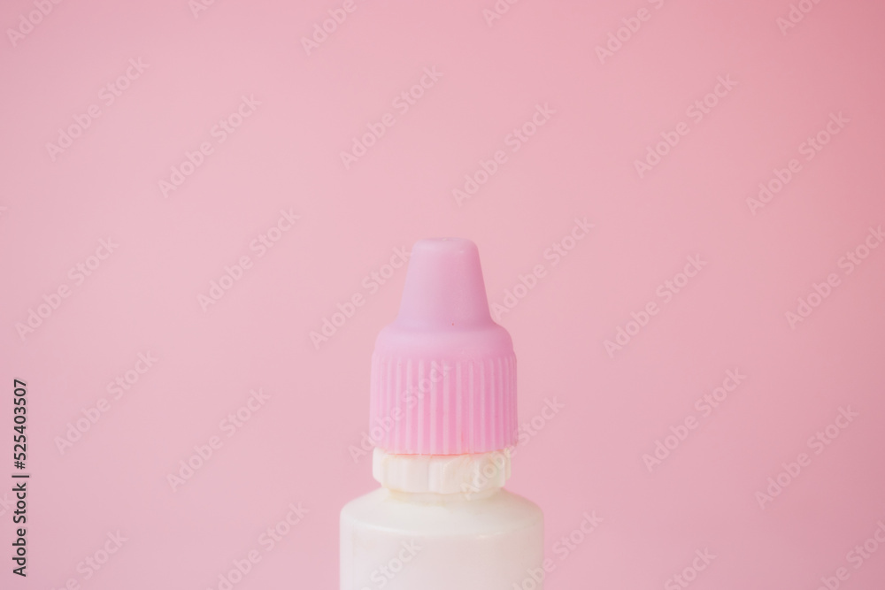 Little white bottle with dropper on pink background Little white bottle with dropper on pink background