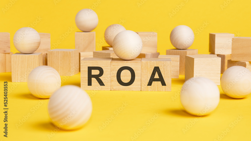 text ROA is written on wooden cubes. bright yellow surface. Business concept. wooden sphere balls among the wood cubes, different and position in niche market concept. ROA - short for return on assets text ROA is written on wooden cubes. bright yellow surface. Business concept. wooden sphere balls among the wood cubes, different and position in niche market concept. ROA - short for return on assets