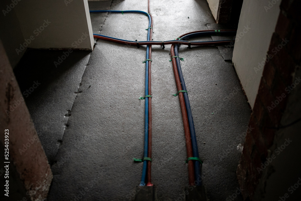 Red and blue pipes of the water supply and heating system in a country