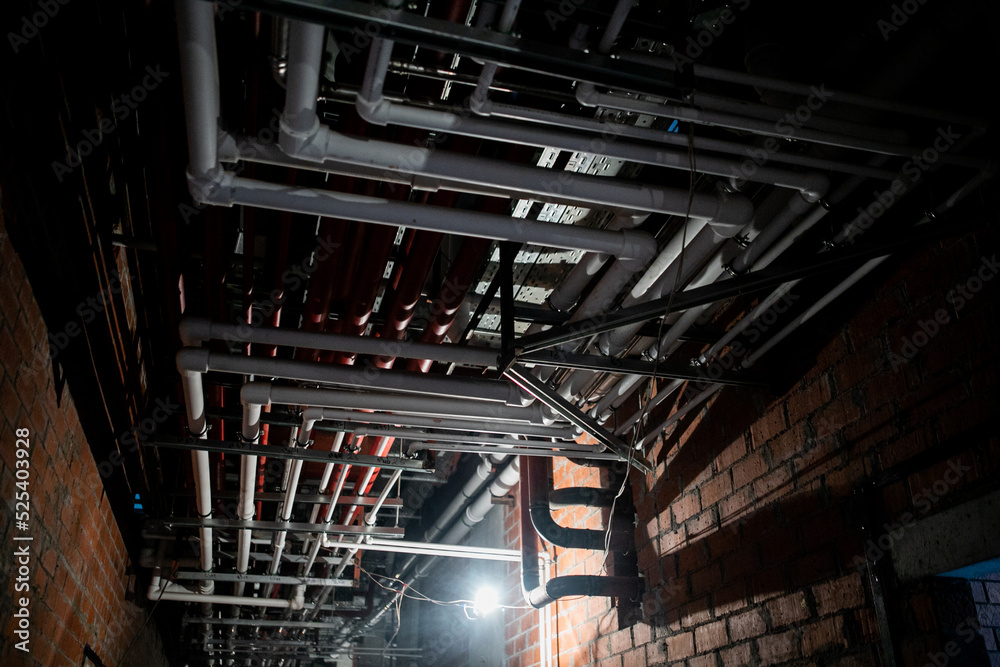 Electrical conduit system and galvanized steel pipe of electric cable installed on ceiling. PVC plastic pipe of drainage system and clean water on industrial building ceiling. Building construction. Electrical conduit system and galvanized steel pipe of electric cable installed on ceiling. PVC plastic pipe of drainage system and clean water on industrial building ceiling. Building construction.